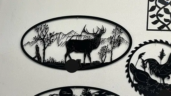 Custom plasma-cut steel wall art panels featuring an elk mountain scene and farm designs