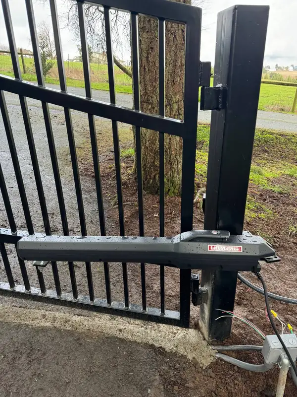 LiftMaster swing arm gate operator mounted on an iron gate post