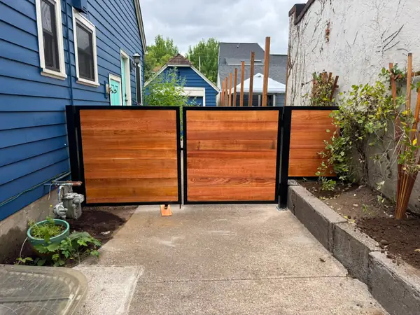 Modern horizontal cedar double swing gate with black steel frame in side yard